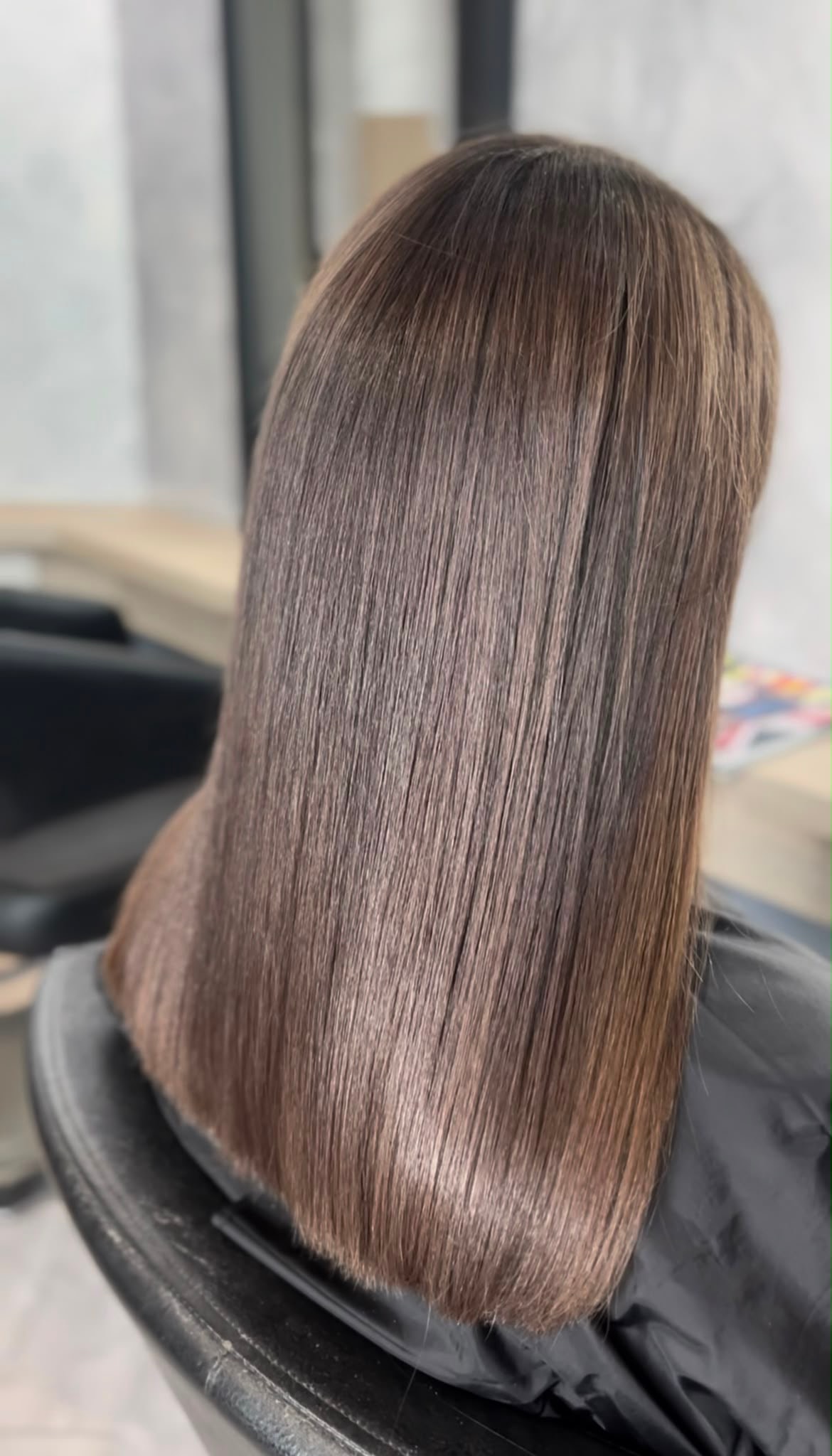 Long straight brunette hair after a precision cut and blow-dry